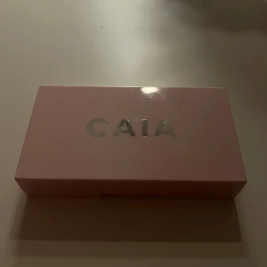 CAIA Prisma Palette Flirty duo - Säljer CAIA Prisma Palette Flirty med två puder – en varm bronzer och en rosatonad rouge. Kommer i en snygg ljusrosa ask med spegel, perfekt att ha i väskan. Paletten har pressade puder med vågigt mönster och ger ett fräscht glow till ansiktet.