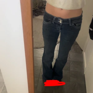 Blå bootcut jeans från Nelly - Säljer ett par blå bootcut jeans från Nelly med låg midja och snygga vita broderade detaljer på bakfickorna. De har bara använts en gång men är uppsydda vid benen så de passar någon som är runt 160. Skriv om du har frågor💕