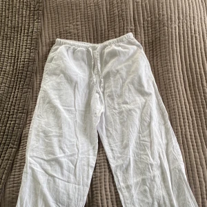Vita linnebyxor från Gina Tricot - Snygga och luftiga vita linnebyxor från Gina Tricot med resår i midjan. Perfekta för varma dagar och chill vibes. Byxorna har en rak passform och är tillverkade i mjukt linnematerial som känns skönt mot huden. Har dock två pyttesmå gula fläckar men syns inte mycket!🌸😃