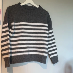 Randig stickad tröja  - Mysig stickad tröja. Säljer då den inte kommer till användning. Använd typ 5-6 gånger och skulle säga att den är jätte fint skick.  Perfekt för dig som gillar en enkel men stilren look. 