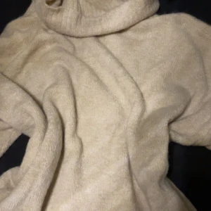 Beige polotröja från ICHI XS - Mysig beige polotröja från ICHI i storlek XS. Tröjan är stickad och har en hög polokrage som ger en chill och avslappnad vibe. Perfekt för lager-på-lager under höst och vinter. Enkel att matcha med jeans eller kjol för en clean look.