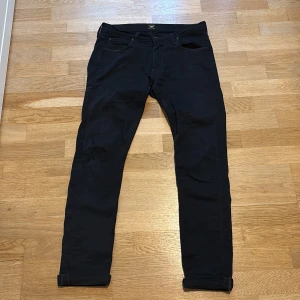 Svarta Lee Luke jeans W30 L32 - Säljer ett par svarta Lee Luke jeans i storlek W30 L32. Jeansen har klassisk femficksdesign, Lee-logga på bakfickan och är tillverkade i en bomullsblandning. Snygg, smal passform med raka ben och diskreta detaljer.