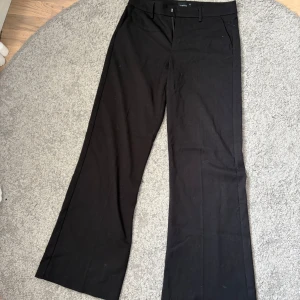 Svarta kostymbyxor med bootcut - Snygga svarta kostymbyxor med bootcut och klassisk passform. Fickor på sidan och en ”låssas ficka” i bak. Aldrig används. 
