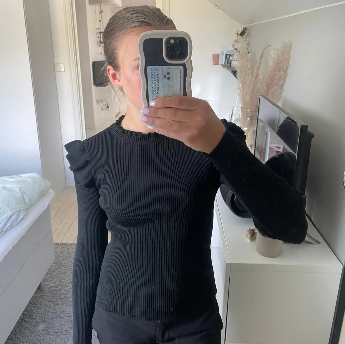 Svart ribbad tröja med volangdetalj