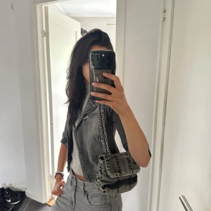 Grå väska - Hej! Säljer denna jättesöta väska som man både kan ha cross-body och som axelremsväska. Enbart använd en gång. Mårten är 25 x 17 cm och tveka inte på att skriva vid frågor och pris kan diskuteras🤗