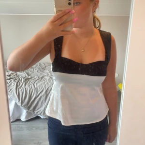 Svart vit topp - En topp som ger Blair Waldorf vibes,har en liten foundation fläck som inte gått bort i tvätten men den märks knappt, säljer denna då den inte kommer till användning