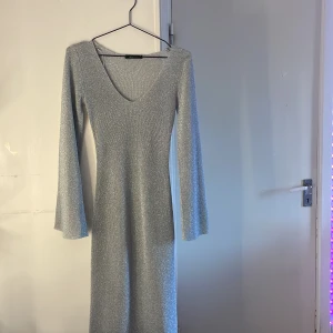 Glittrig silverklänning Gina Tricot XS - OBS helt oanvänd. Supersnygg figursydd långklänning i glittrigt silver från Gina Tricot passar perfekt för om man vill ha nått som inte e för mycket men inte för litet. Jätte enkel att styla och är ner till fötterna på mig som är 1,61 cm. Inget fel på klänningen men säljer för att jag köpte fel sedan bestämde mig för och behålla den men har inte kommit till andväning🤍🤍.