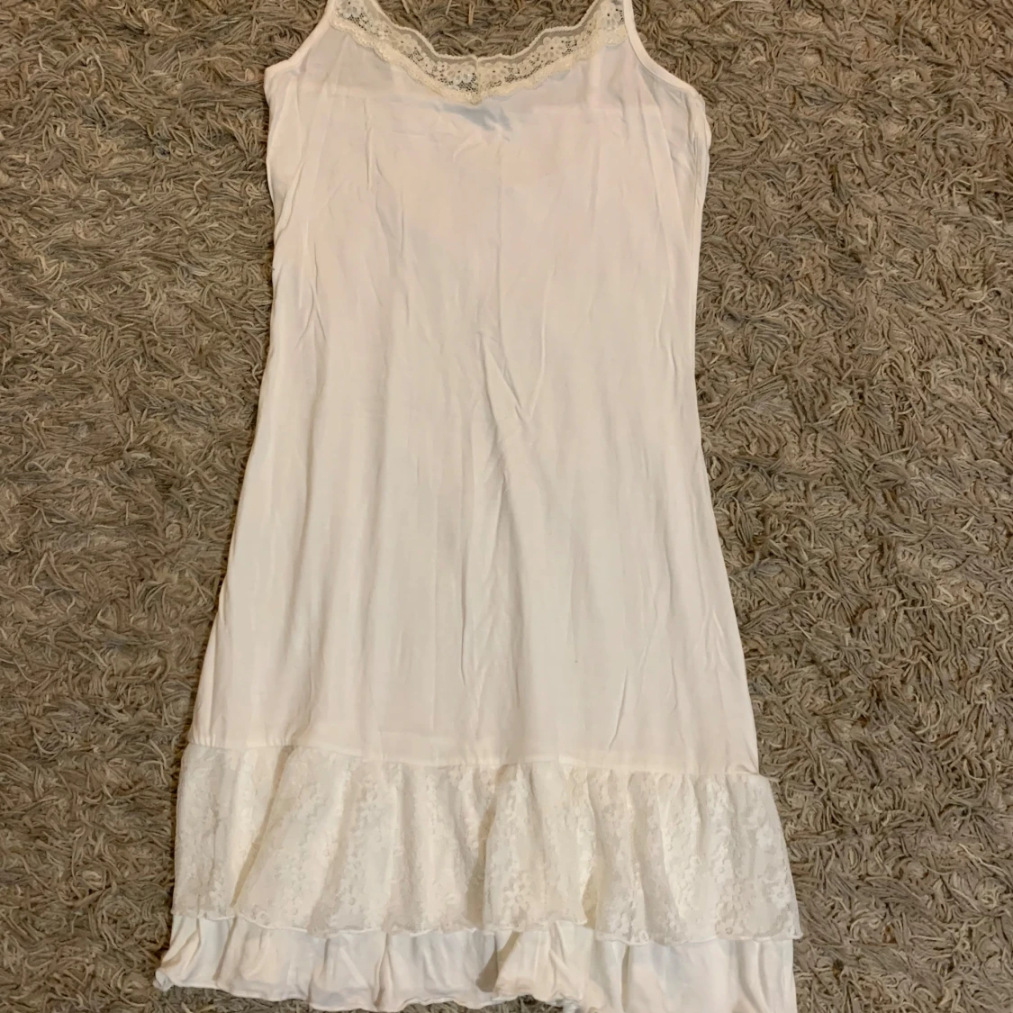 Vit spetsklänning med volangkant