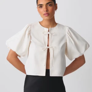 Vit blus med puffärm från Gina Tricot - Superfin vit blus med korta puffärmar och två knytningar framtill. Storlek S. Har en liten defekt (se bild 3), men inget som syns vid användning. Nypris 399kr. 🌸✨