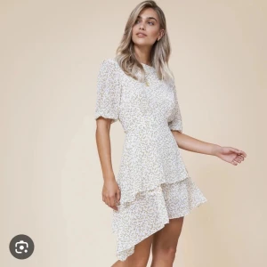 Vit blommig kortklänning med volang - Adoore som inte används längre!