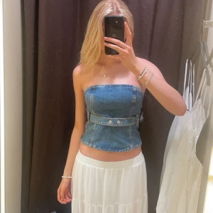 Tubtopp i denim  - Jättestrechigt material! Bara två av knapparna går att öppna, men det gör ingen skillnad då den har dragkedja på sidan. 