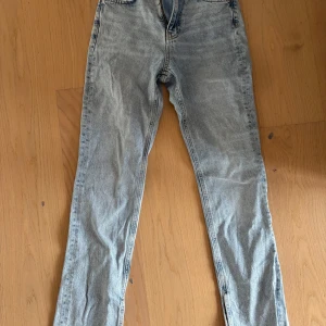 Ljusblå jeans med rå kant - Säljer ett par ljusblå jeans med rak passform och rå, fransig kant vid bensluten. Jeansen har klassisk femficksdesign och är tillverkade i slitstarkt denim. Perfekt för dig som gillar en avslappnad och trendig look.