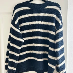 Randig stickad tröja i marinblått - Säljer en mysig stickad tröja med marinblå och vita ränder.