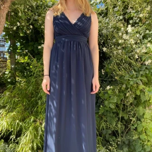 Marinblå omlott festklänning - Marinblå långklänning med omlott sydd topp del och vringning. En mycket lyxig  och elegant blå festklänning / balklänning från Vila, endast använd en gång, i storlek S ❣️ #prom #långklänning #promdress #balklänning #festklänning #vila  #marine #marinblå  #vringad #omlott 