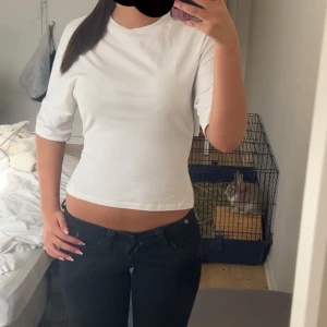 Vit tröja med knyt  rosett  i ryggen - Säljer vit topp med snören i bak som man kan knyta till en söt rosett, väldigt bra skick .