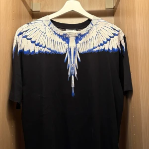 Svart t-shirt med blått fågeltryck - En mycket fin Marcelo burken T-shirt, självklart äkta. Storlek S men passar perfekt för mig som är 182 Alltså storlek M. Köpt 2022 på Urban mode 