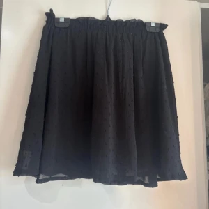 Svart kjol - Säljer en svart kjol från H&M Divided. Midjebandet har skruvat till sig lite baktill (se sista bilden) men är i annars bra skick.