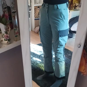 Skidbyxor från Warp - Säljer ett par mintgröna/turkosa skidbyxor från Warp med stora cargofickor på sidorna. Byxorna är gjorda i slitstarkt och vattentätt syntetmaterial. Perfekta för vinterns äventyr eller skidbacken!🩵💚🏂⛷️Bara använda en gång och är mer eller mindre nyskick. Gissar att nypris är ca 900 kr. Det är bara att skriva om man har frågor!😊💖