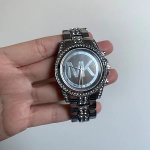 Silver klocka med stenar Michael Kors - Snygg och glittrig klocka  i silverfärg, knappt använd. Ej äkta, batteriet behöver bytas ut. 