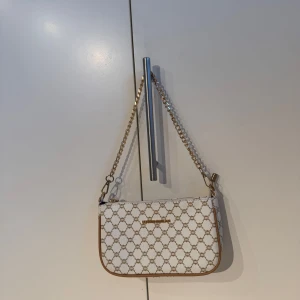 Vit väska  - Vit axelväska. Man får även med ett långt band. Använd 3 gånger