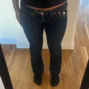 True Religion Jeans - Jättefina mörkblå jeans från True Religion med låg midja. De är i storlek 25 som jag skulle uppskatta är en xs/30”. De har en rak passform i benen och är använda sparsamt💞Skriv till mig för mått och andra frågor!