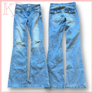 Bootcut jeans med slitningar från Nelly - Blå bootcut jeans från Nelly med låg midja och slitna detaljer vid knäna. Klassisk femficksmodell med dubbla knappar i midjan och ljus tvätt. Jeansen har breda ben och är tillverkade i jeansmaterial med snygg faded effekt.