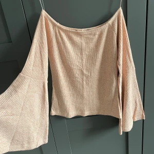 Rosa off shoulder topp med vid ärm - Rosa ribbad off-shoulder topp med vida ärmar. Från BikBok i storlek S.
