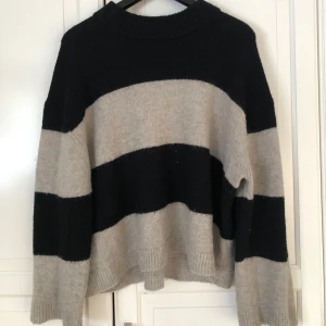 Randig tröja från Gina Tricot - Säljer en mysig randig tröja från Gina Tricot i svart och beige. Tröjan är sparsamt använd! 