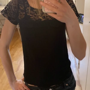 Svart spetsblus - Säljer en snygg topp med spetsdetalj på överdelen och med korta ärmar. 🫶