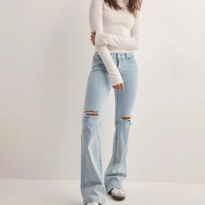 Ljusblå bootcut jeans med slitningar - Snygga ljusblå jeans med bootcut-stil och slitningar på knäna. Dom är väldigt bekväma men tyvärr alldeles för långa för mig (jag är 165). Inte andvända så mycket då dom är för långa. ❤️nypris: 699kr 