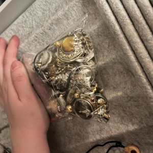 Blandade smycken i guld och silver - En samling av blandade smycken i guld och silver, inklusive armband, halsband och ringar och örhängen. Vissa smycken har pärlor och stenar i olika färger. Perfekt för att mixa och matcha till olika outfits. Bra pris för hela påsen men priset är ok att diskutera. 