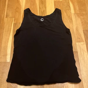 Svart linnetopp  - Säljer en stilren svart linnetopp från märket Cubus. Perfekt för varma dagar eller som lager under andra plagg och även som basplagg. Toppen har en klassisk design med rund halsringning och ärmlös stil.