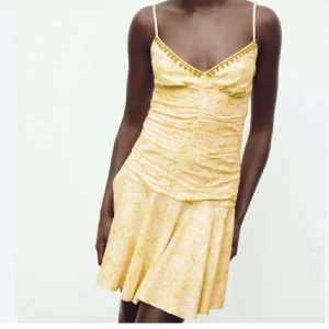 Gul klänning - Snygg gul klänning från Zara som inte finns i butik längre. Klänningen har ett subtilt mönster och en lätt volangdetalj vid fållen. Perfekt nu till sommaren! 