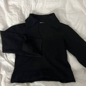 Svart stickad tröja från Gina Tricot - Säljer en svart stickad tröja från Gina Tricot med krage och långa ärmar med slits. Väldigt skönt material💗⭐️