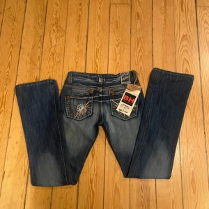 Lågmidjade bh jeans  - Snygga blå jeans från BH Jeans med unikt broderi och nitar på fickorna. De har fortfarande lappen kvar. Midjemåttet är 35 rakt över o inbenslängden är 79🥰