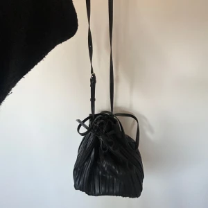 Väska - Väskan är rymlig och har en knytbar stängning upptill. Köpt begagnat men själv aldrig använt