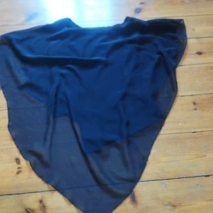 Svart poncho - Elegant svart poncho med ett luftigt och flödande tyg. Toppen är perfekt för att lägga till en touch av stil till din outfit.