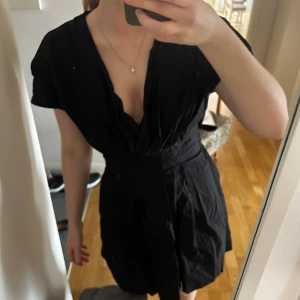 Svart kortklänning med v-ringning - Jätte söt svart kortklänning med v-ringad design och korta ärmar. Klänningen har en omlottstil och är ganska kort. Köpt från Sellpy men är från Zara. Säljer då den tyvärr var för kort för mig som är runt 1.70.💕💕 