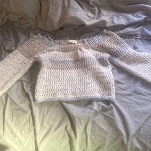 Beige och blå stickad tröja - Säljer en mysig stickad tröja från Zara i beige och blå nyanser. Tröjan har ett randigt mönster och långa ärmar. Perfekt för kyliga dagar!