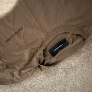 Brun t-shirt från Peak Performance - Säljer en brun t-shirt från Peak Performance. Den har en enkel design med korta ärmar och rund hals. Storlek M, pris ej hugget i sten