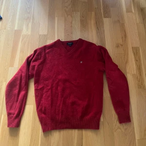 Röd v-ringad tröja från GANT - Säljer en klassisk röd v-ringad tröja från GANT i storlek M men passar S. Tröjan har långa ärmar och ribbade muddar vid ärmslut och nederkant. Den är gjord i ull. Använd många gånger men inga tecken på det💓
