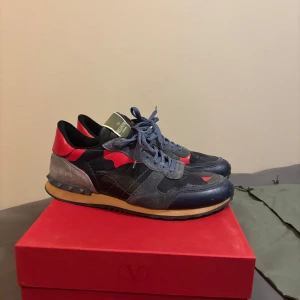 Valentino Rockrunner sneakers med OG tillbehör  - Säljer ett par Valentino Rockrunner sneakers i blått och rött med grå detaljer. Med låda och dustbag inkluderat. Denna modell med denna färg är sällsynt och finns inte alls att köpa längre. Skorna är i superskick och har tyvärr helt enkelt inte fått någon användning förutom från när jag köpte dom i en kort period. Skorna är i storlek 45 och jag kan skicka fler bilder vid behov. Tack!