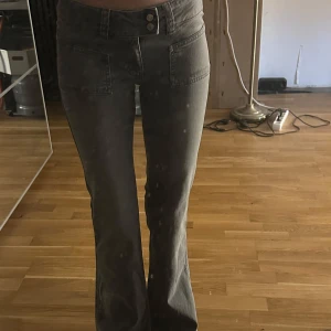 Grå low waist bootcut jeans med fickor från lager 157 - Säljer ett par gråa bootcut jeans med stora framfickor och dubbla knappar i midjan. De är från lager 157, alldrig använda, i storlek s full length! Low waist och perfekt bootcut! Kaxiga och coola!