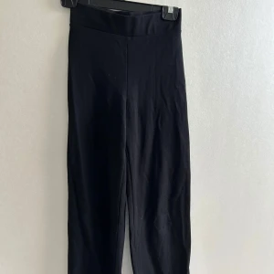 Svarta kostymbyxor med hög midja - Säljer ett par svarta kostymbyxor med hög midja och raka ben. Byxorna har en stilren look utan synliga detaljer som knappar eller dragkedja framtill💗💗