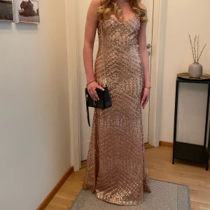 Balklänning  - Jättefin balklänning med paljetter! Paljetter i ett fint mönster i en guld/roséguld färg. Dragkedja i ryggen, justerbara band. Bara använd 1 gång, superbra skick💕 min syster på de två första bilderna är 168cm, jag på de två andra är 170cm.