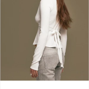 Vit topp från nelly - Säljer en vit långärmad topp med knytning på ryggen💞sällan använd men den är rn fläck på framsidan som jag inte har fått bort i tvätten därav de låga priset💞💞