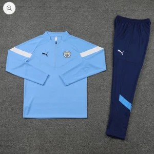 Manchester City långärmad träningströja och byxor från Puma - Manchester City långärmad träningströja i ljusblått med vita detaljer och klubbmärke på bröstet. Matchande mörkblå träningsbyxor med ljusblå detalj och Puma-logga. Perfekt för fotbollsträning.