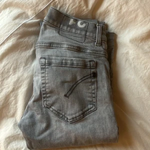 Grå jeans från Dondup - Säljer ett par snygga grå jeans från Dondup. Jeansen har klassisk design, raka ben och diskreta slitningar framtill. 9/10 Skriv dm vid frågor.
