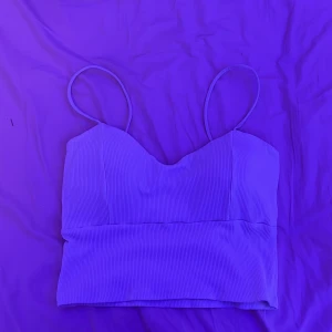 Ribbad vit croppad linnetopp - Säljer en stilren vit croppad linnetopp med tunna axelband och ribbad struktur. Perfekt för varma dagar och enkel att matcha med olika outfits.