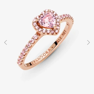 Pandora ring - Superfin ring i roséguld från Pandora med en hjärtformad rosa sten i mitten. Knappt använd och i ny condition. Nypris 1199kr